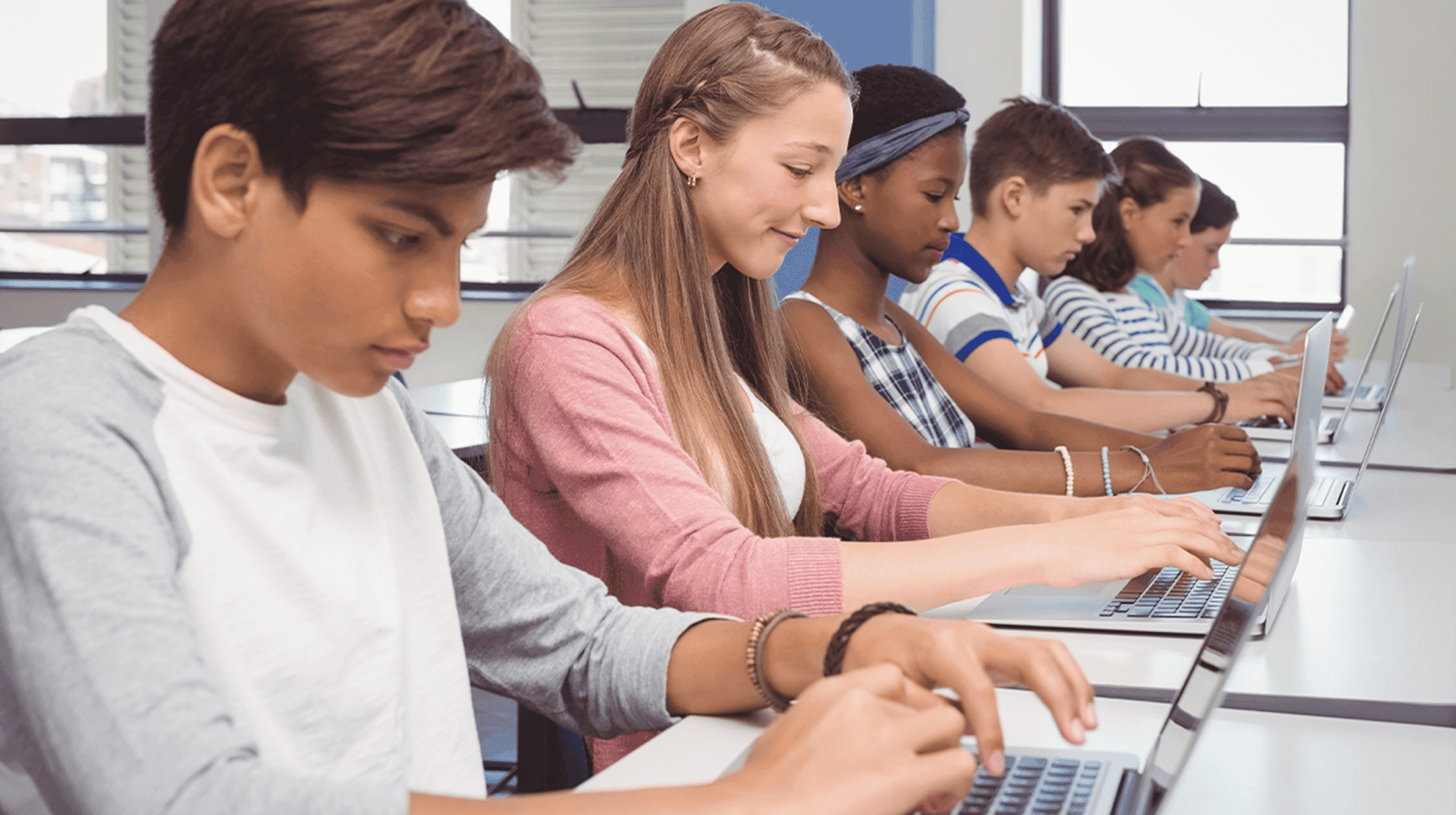 Image of row of students engaged in school work on their laptops