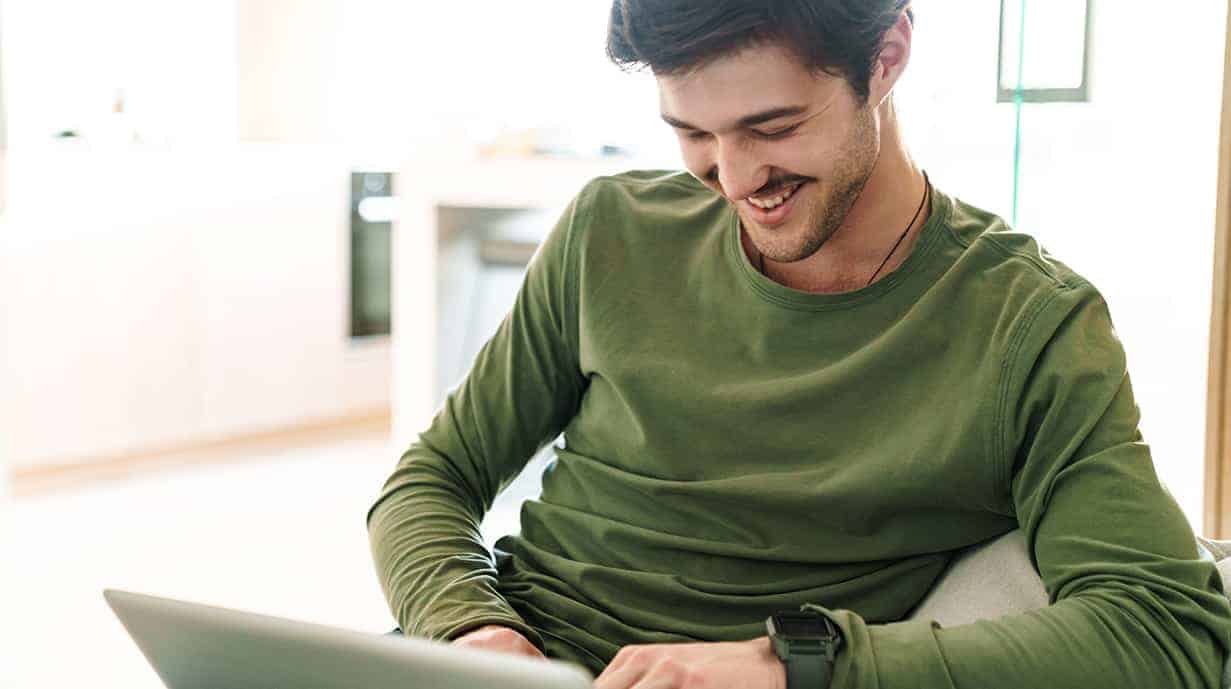 Image of ecstatic man looking at laptop screen
