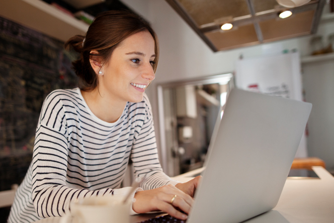 Woman happily using laptop