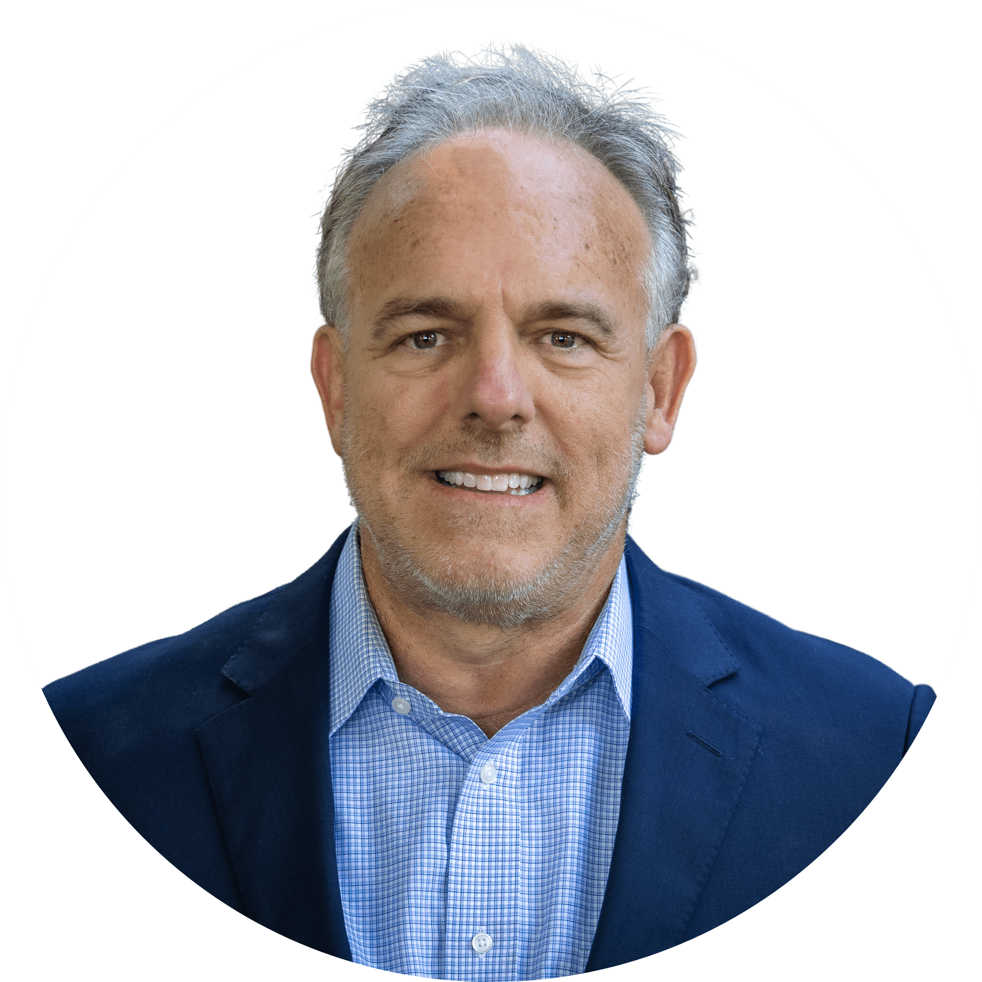 A man with gray hair smiles at the camera, wearing a blue checkered shirt and navy blazer against a plain white background.